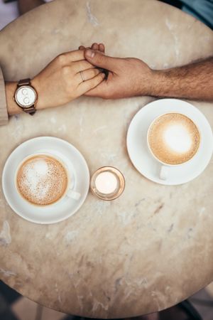 Hands of couple together on a coffee table