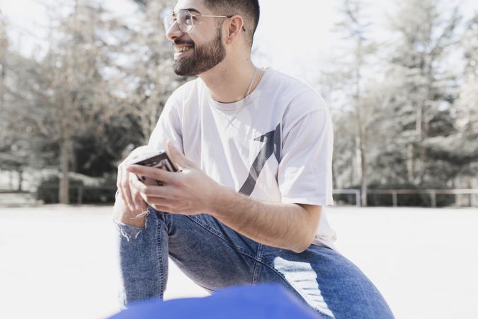 Handsome positive man using smartphone
