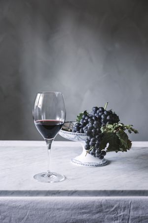 Bunch of grapes on plate and glass of wine