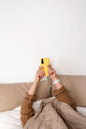 Person using smartphone in bed