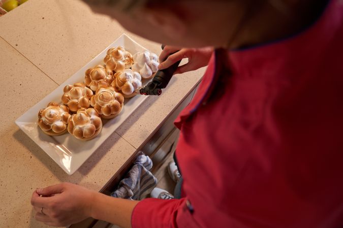 Woman preparing homemade baked tartlets in kitchen