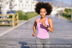 Black woman, afro hairstyle, running outdoors in city road 5olgy4