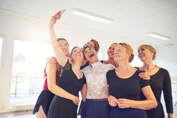 Group of happy women take selfie in bright dance studio