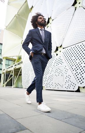 Male office worker walking near modern building