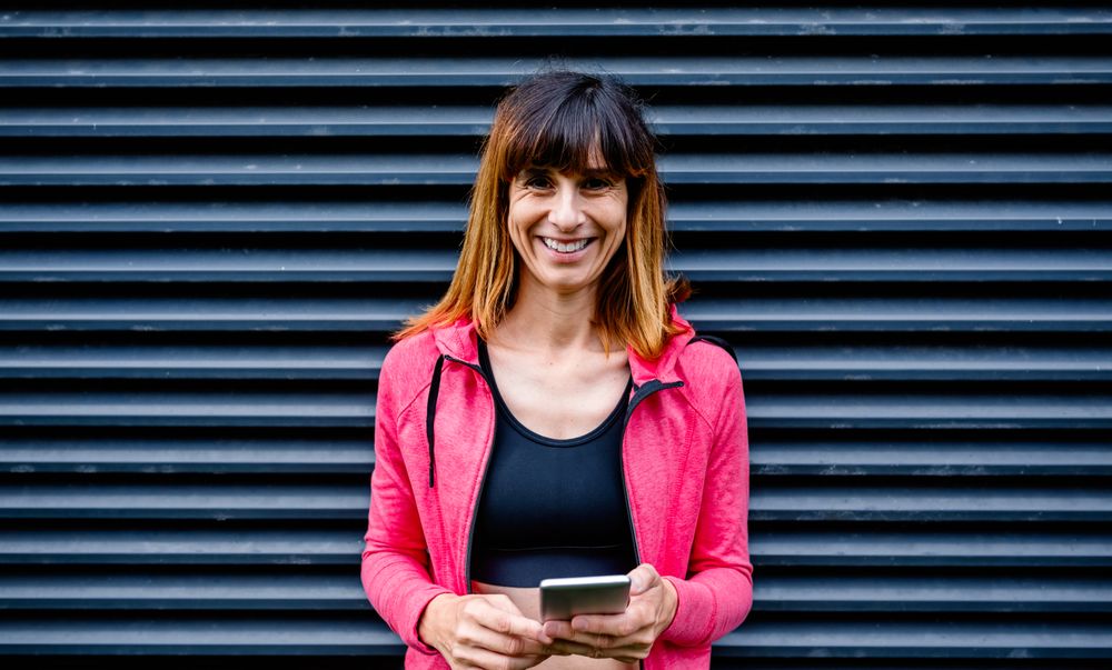 Happy female athlete with mobile phone