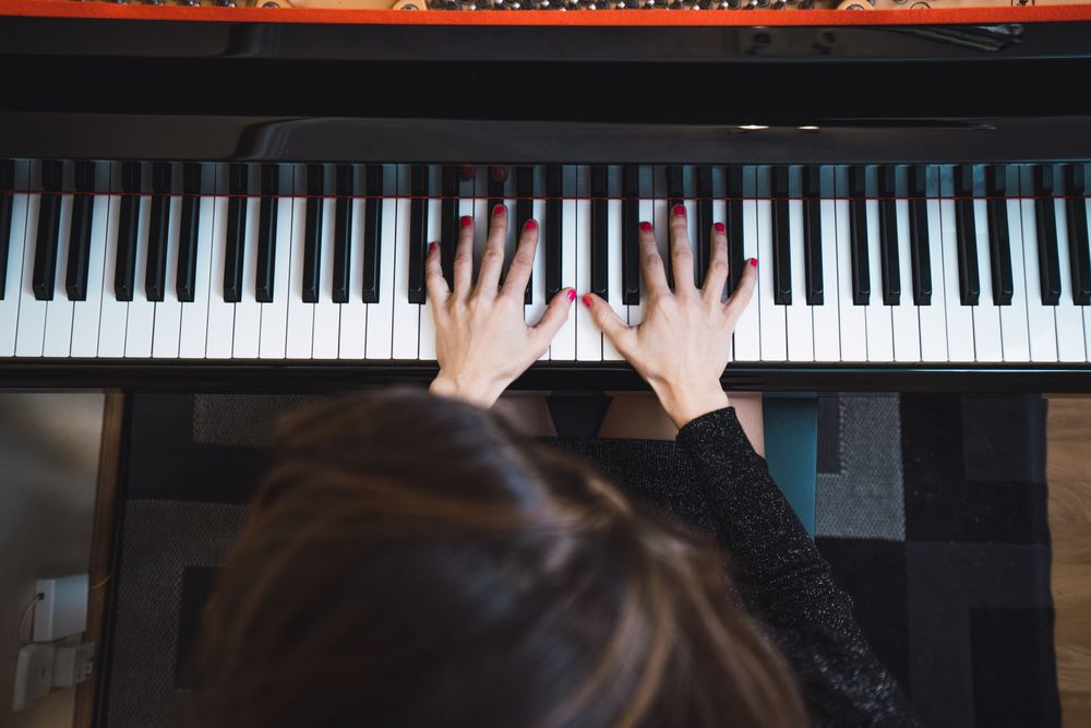 Top view of cropped hands playing the piano