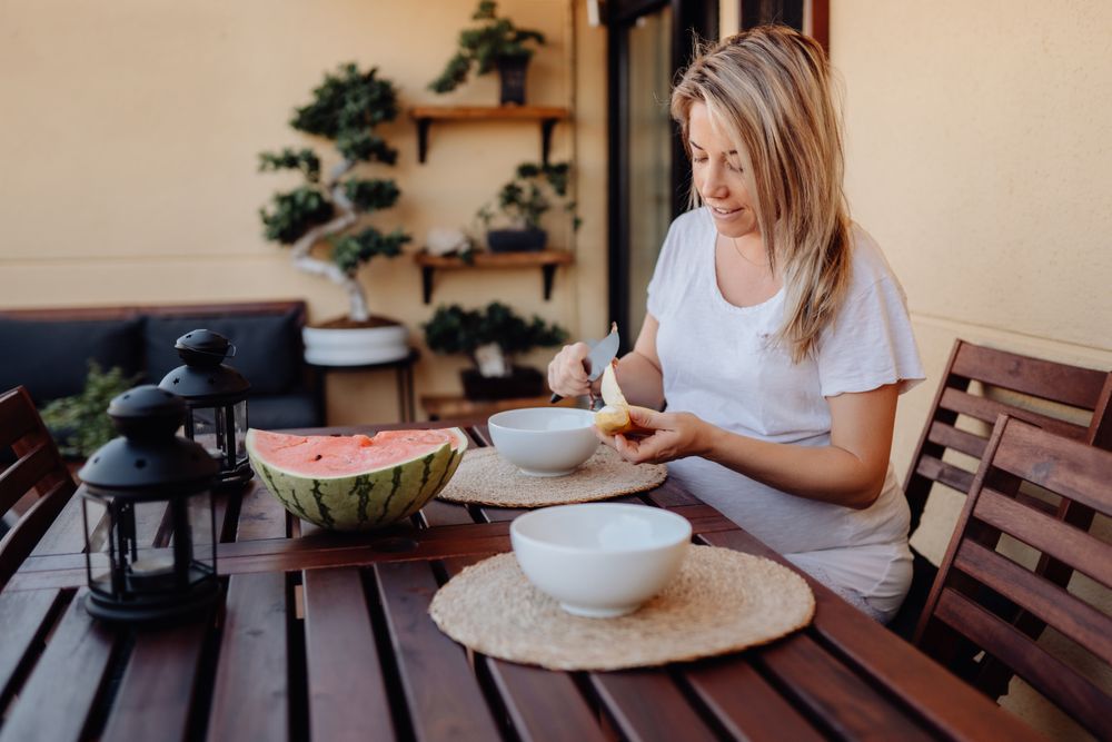 Pregnant woman cutting banana to bowl