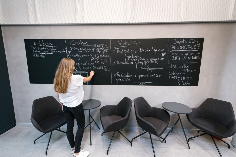 Woman writing on board in office