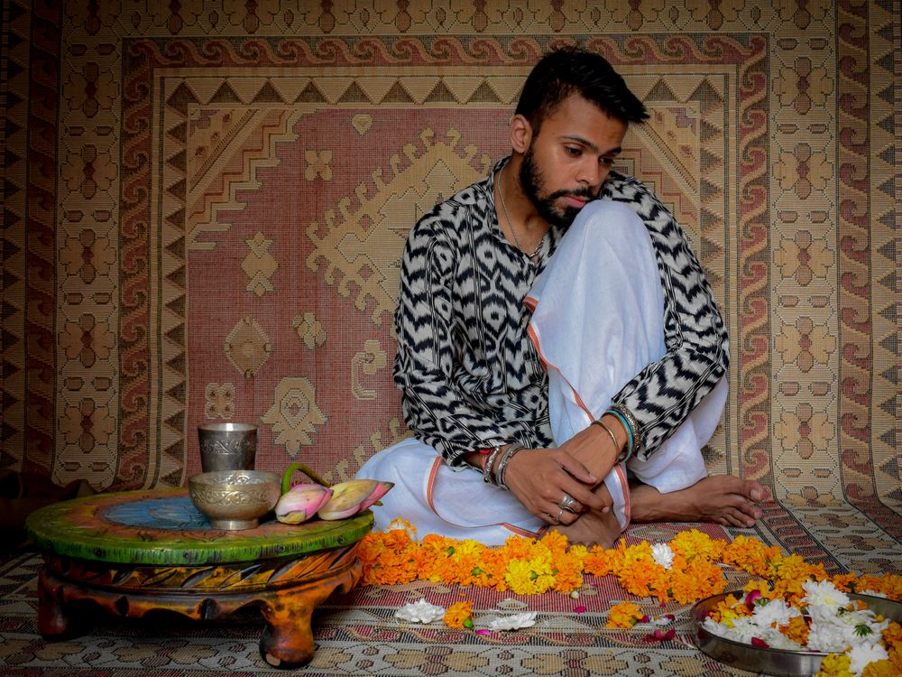 Man sitting on floor beside tray and orange garland