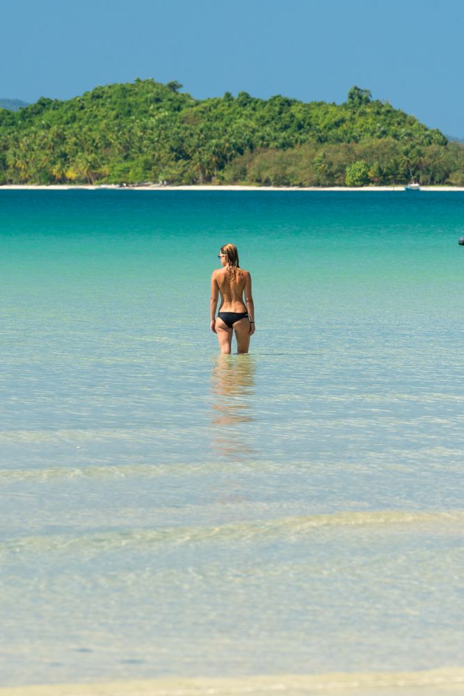 Woman resting in water on tropical seashore