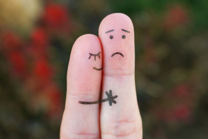 Fingers art of displeased couple. Man is sad, woman reassures him.