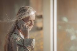 Traveling woman speaking on the phone near an airport