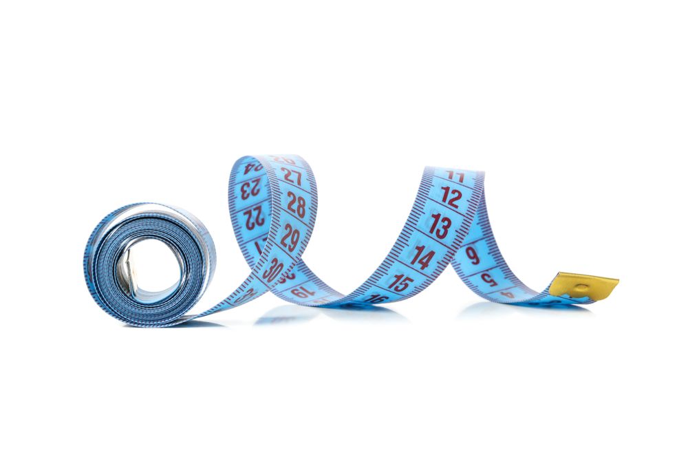 Measuring tape isolated on light background. Weight loss