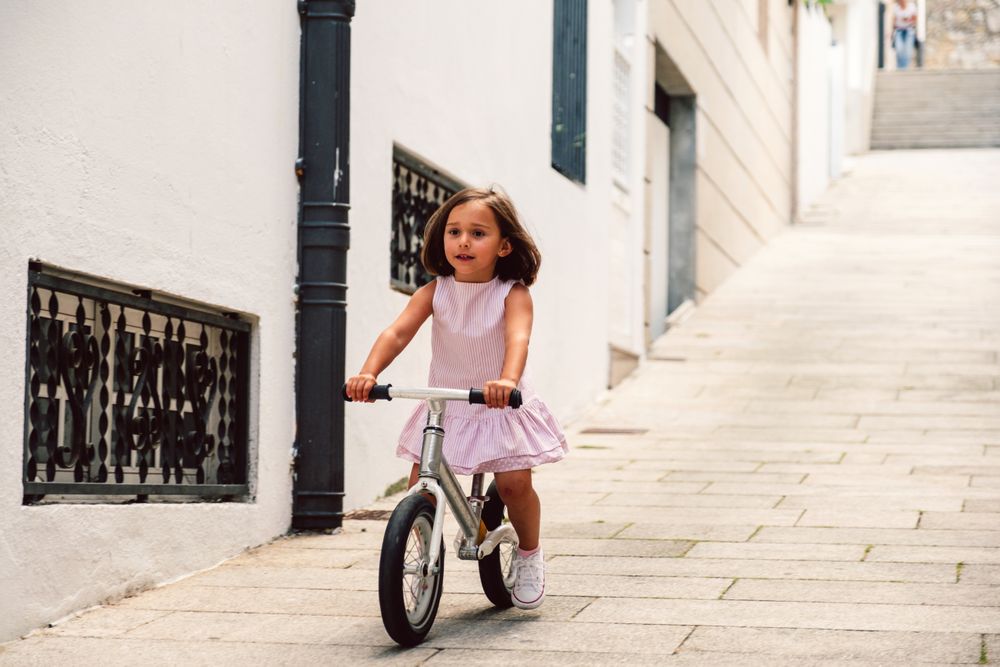 Girl riding on bicycle in narrow street