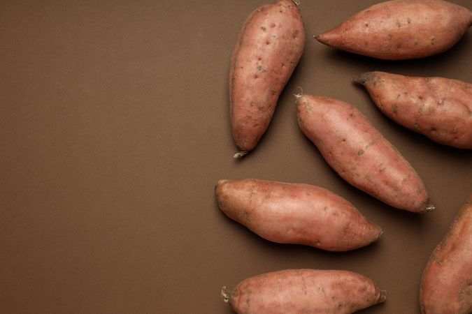 Fresh sweet potato on a brown background