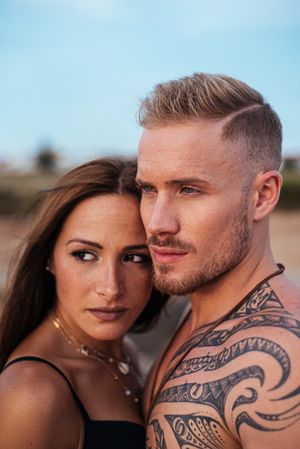 Cool dreamy couple in swimwear on shore