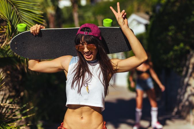 Attractive young woman with skateboard on summer vacation
