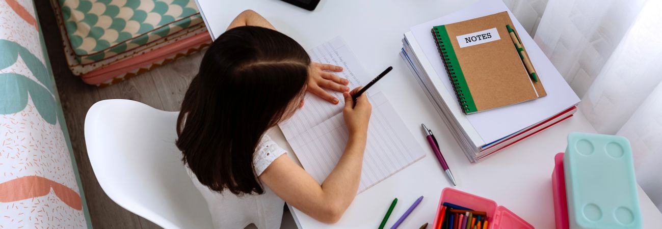 Girl doing homework in her bedroom