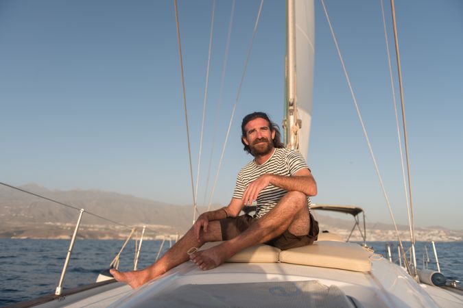 Smiling man on yacht on water