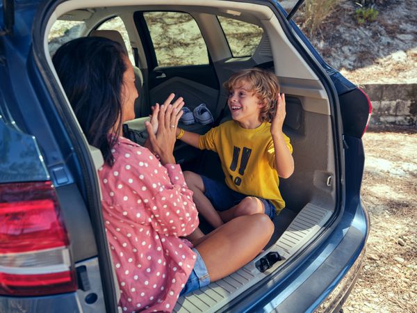 Joyful son playing with mother in car