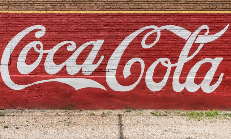 An old, painted Coca-Cola sign on the side of a building in the town of Grand Saline, Texas