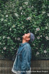 Man standing beside flowers while looking up 0VJrj0