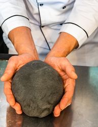 Person making squid ink pasta dough