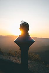 Astronomical telescope set on street at sunset