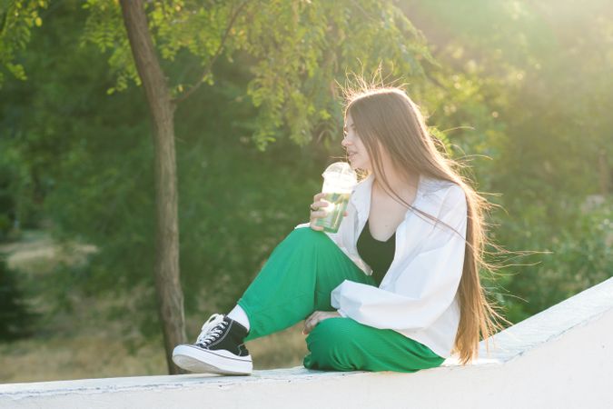 Teen girl drink soft drink on walk in park