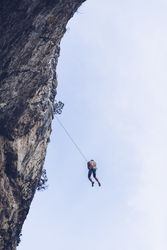 Anonymous climber handing on cliff