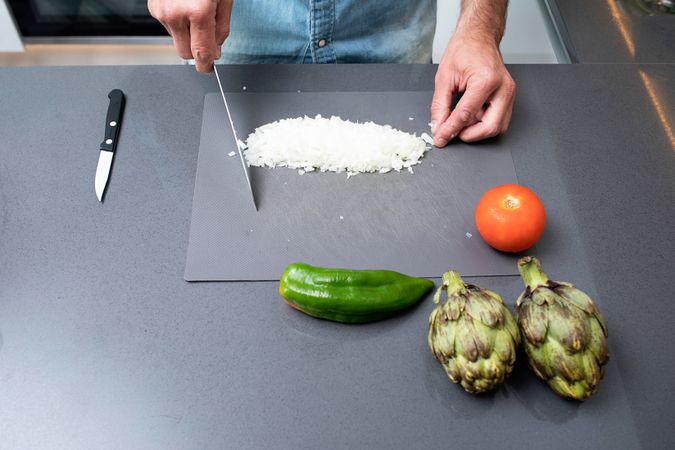 Man prepping onion on kitchen counter