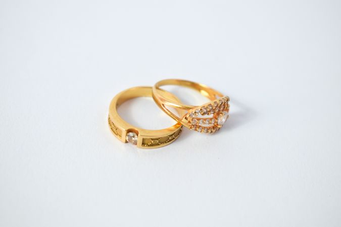 Two diamond gold rings on plain table with copy space