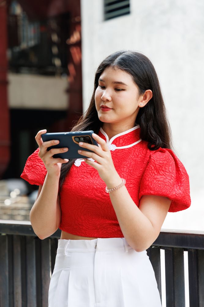 Asian person playing on mobile phone, watching video clip