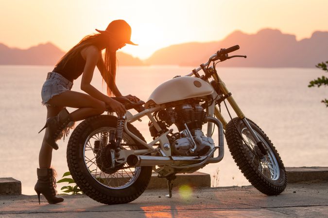 Woman with motorbike near sea