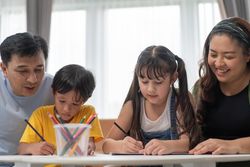 Asian parents doing homework with their children at home