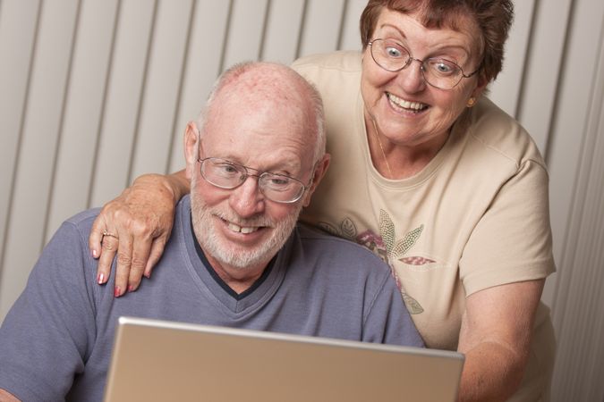 Smiling Mature Adult Couple Having Fun on the Computer