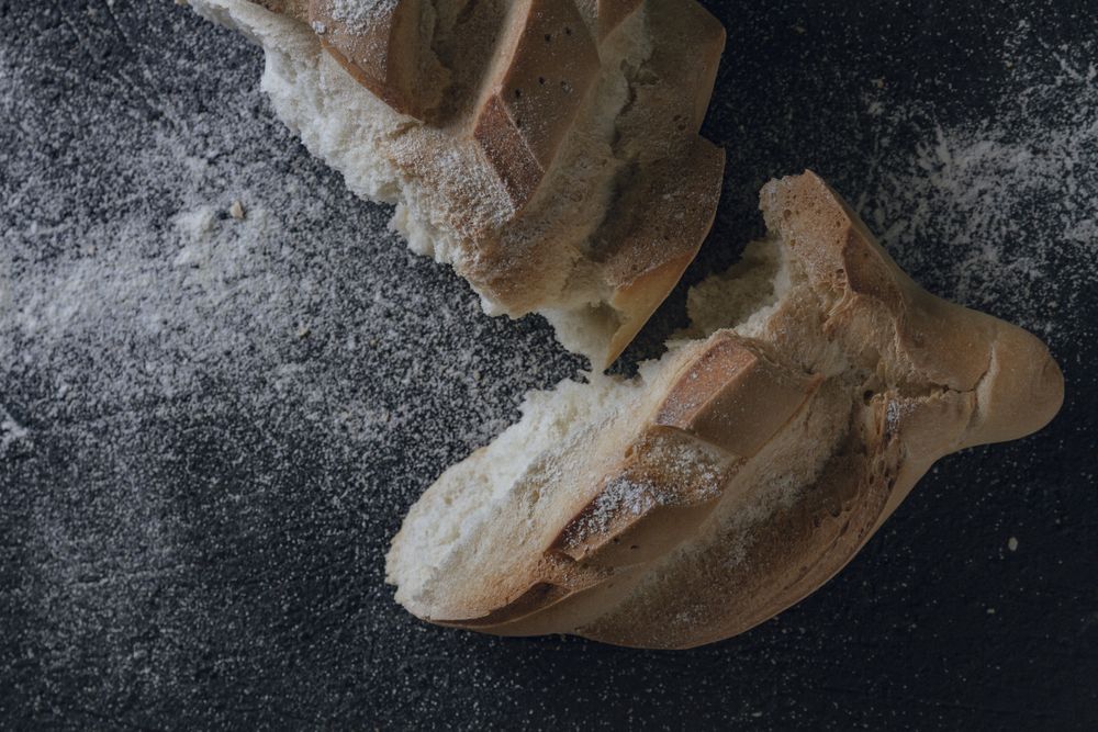 Loaf of bread with incisions on grey texture background