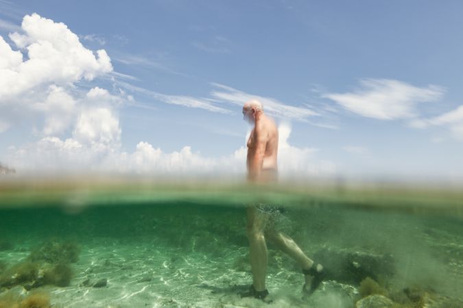 Cheerful man swimming in sea water