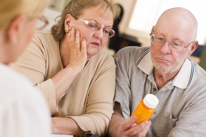 Doctor or Nurse Explaining Prescription Medicine to Older Couple