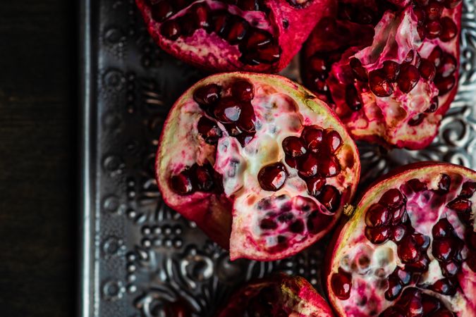 Close up of open pomegranate on silver ornate tray