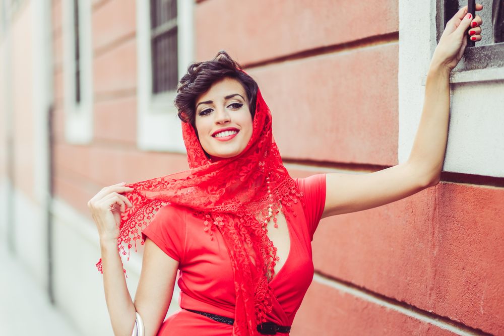 Elegant woman with lace scarf holding onto into railing