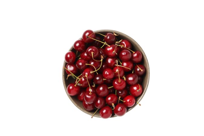 ripe cherry fruits in a bowl, isolated on light background