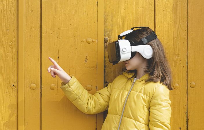 Girl in yellow jacket wearing VR headset