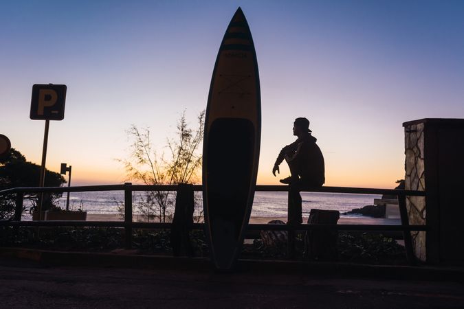 Man practicing paddle surfing with neoprene in a sunrise