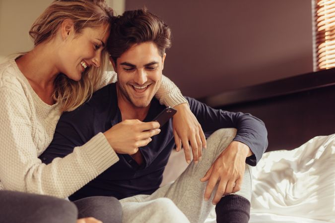 Loving man and woman smiling with a cell phone