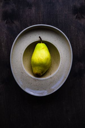 Organic ripe pear in grey bowl