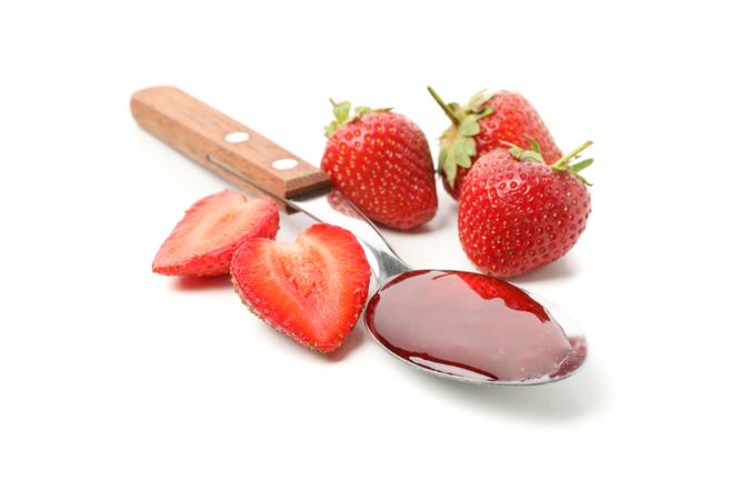 Strawberry and spoon with strawberry jam isolated on plain background