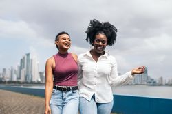 Women talking and laughing walking along the seafront in Panama City