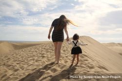 Mother and daughter standing in desert 0PWmmb