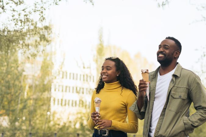Black couple eating ice cream in a park